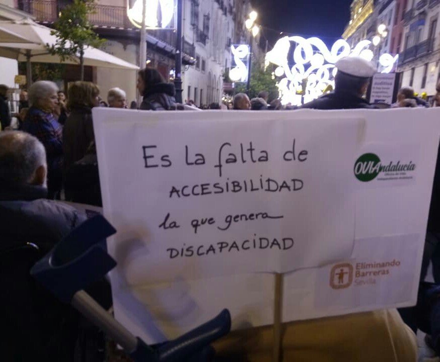 En una calle Sevillana los manifestantes portan una pancarta que dice: Es la falta de accesibilidad la que genera discapacidad