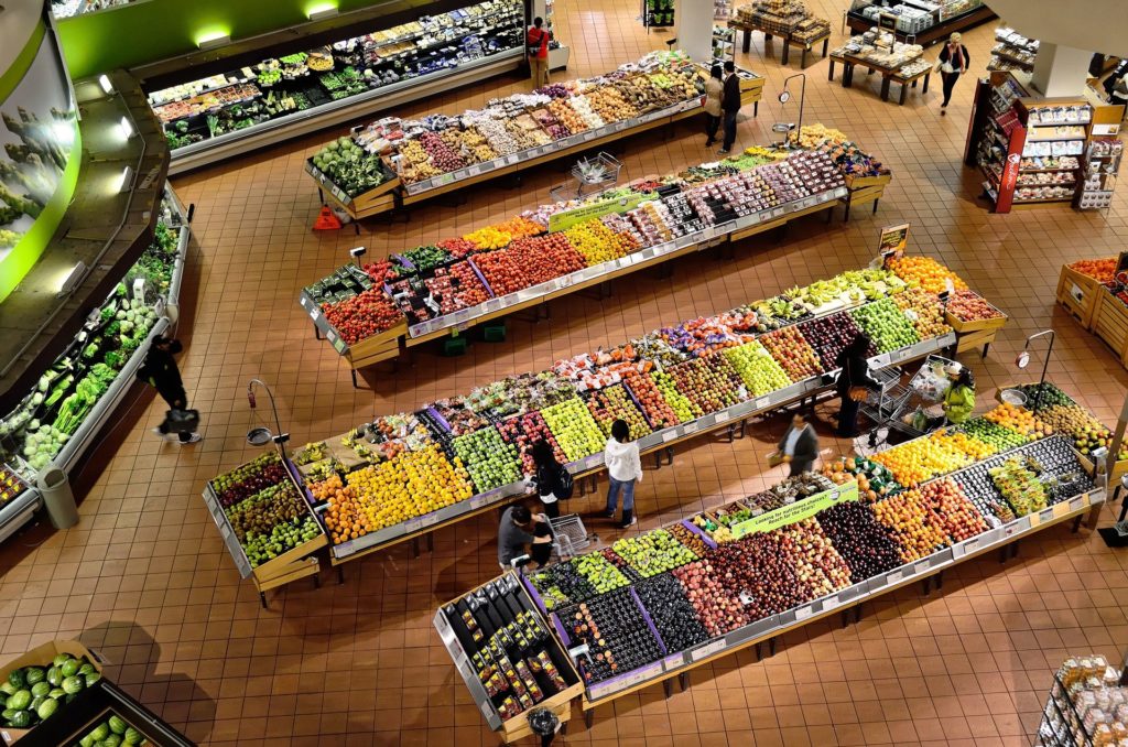 Vista cenital de distintos mostradores de frutas y verduras de un supermercado